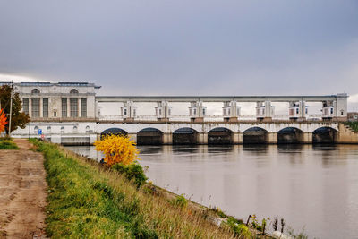 Arch bridge over river against sky