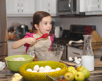 Portrait of cute girl holding food at home