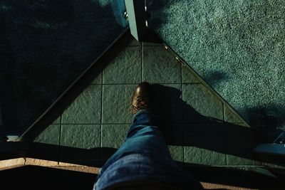 Low section of man standing on tiled floor