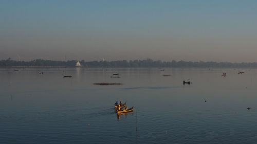 People boating on river during sunset