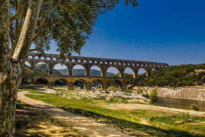 Arch bridge against clear blue sky