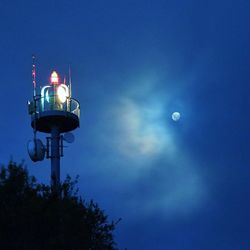 Low angle view of illuminated street light against blue sky