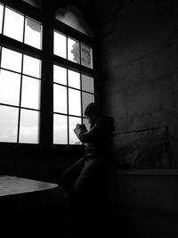 Boy looking through window at home