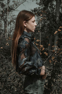 Side view of young woman in forest