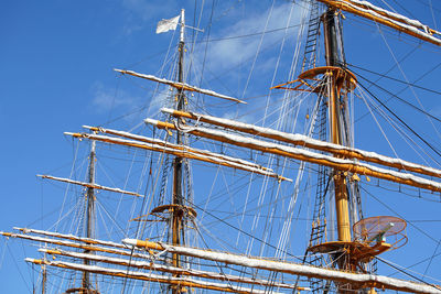 Low angle view of sailing ship against clear blue sky