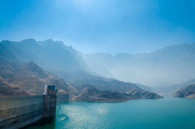 Scenic view of lake and mountains against blue sky