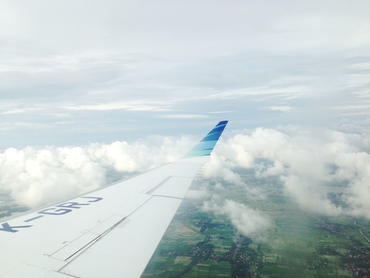 AERIAL VIEW OF AIRCRAFT WING AGAINST SKY