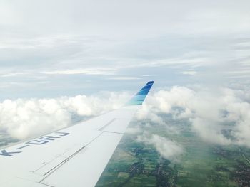 Airplane flying over clouds against sky