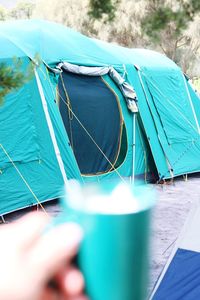 Close-up of hand holding tent