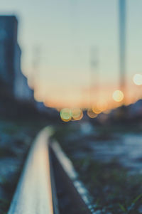 Close-up of railroad tracks against sky during sunset