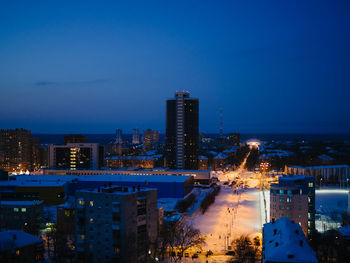 Illuminated cityscape against sky at dusk