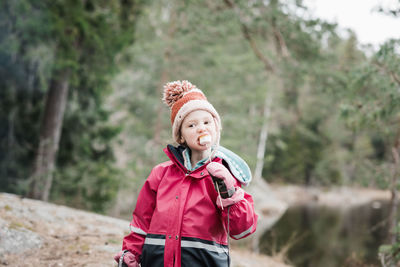 Young girl eating marshmallows whilst camping in a forest in sweden