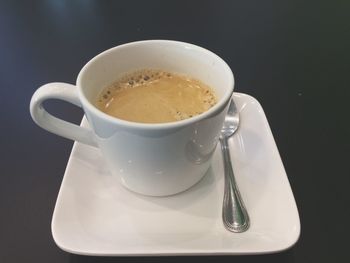 Close-up of coffee cup on table against black background