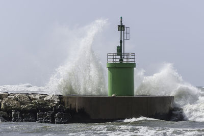 Lighthouse by sea against sky