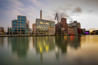 Reflection of buildings in river against sky