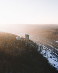 Scenic view of snow covered landscape and ruin castle against clear sky