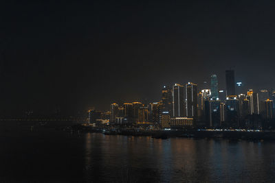Illuminated buildings in city against sky at night
