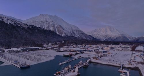 Scenic view of lake by snowcapped mountains against sky