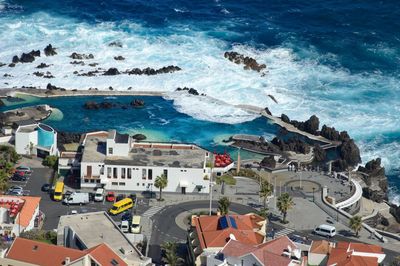 High angle view of houses by sea against sky