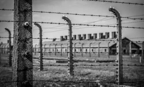 Close-up of barbed wire fence against building