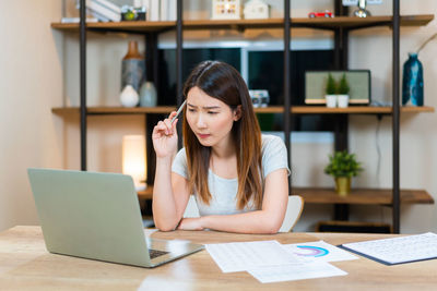 Young woman using laptop at table