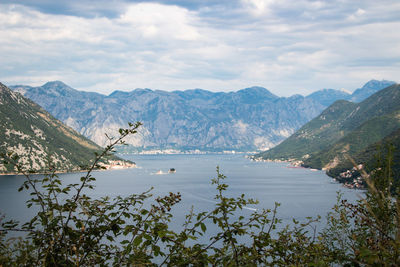 Scenic view of lake by mountains against sky