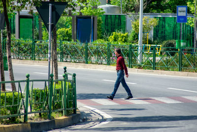 Full length side view of a man walking on road