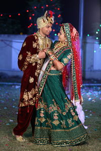 Full length of bride and bridegroom holding hands during wedding ceremony