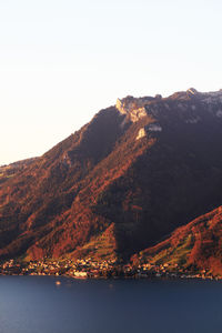 Scenic view of sea and mountains against clear sky