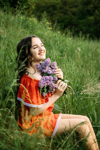 Beautiful woman sitting on field