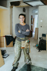 Portrait of confident female construction manager standing with arms crossed at site