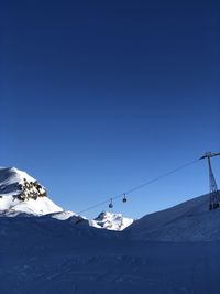 Snow covered mountain against clear blue sky