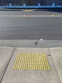 High angle view of yellow arrow symbol on road in city