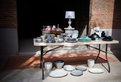 Earthenware on table against wall