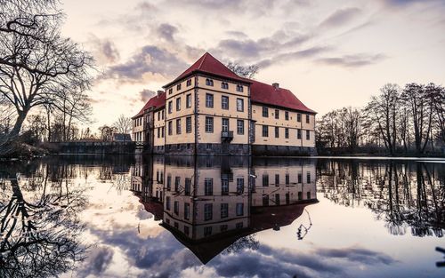 Reflection of building on lake against sky