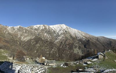 Scenic view of snowcapped mountains against clear blue sky