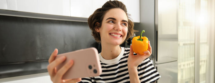 Young woman using mobile phone at home