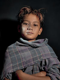 Portrait of teenage girl against black background