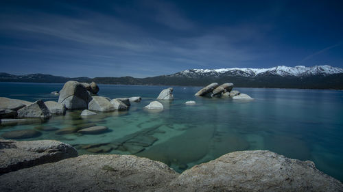 Scenic view of sea and snowcapped mountain against sky