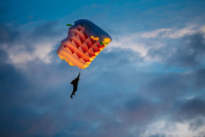 Low angle view of person paragliding against sky