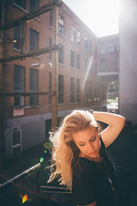 Young woman standing against buildings in city