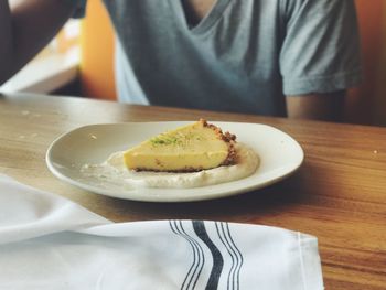 Midsection of man eating food at table