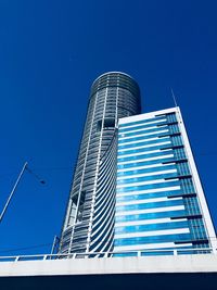 Low angle view of modern building against blue sky