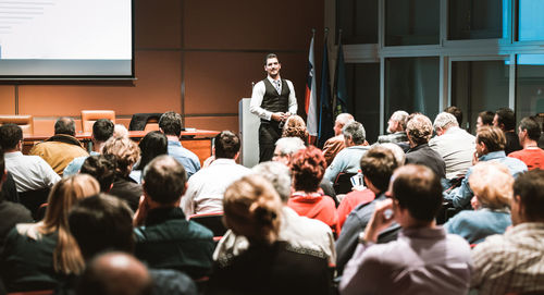 Business speaker giving a talk at business conference meeting event.