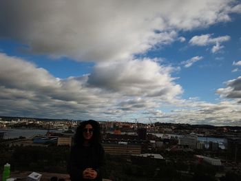 Man in city against sky