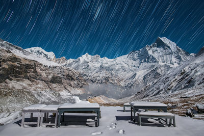 Snowcapped mountains against star trails