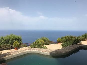 Scenic view of swimming pool by sea against sky