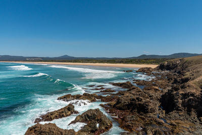 Scenic view of beach against clear blue sky