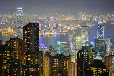 Illuminated cityscape against sky at night