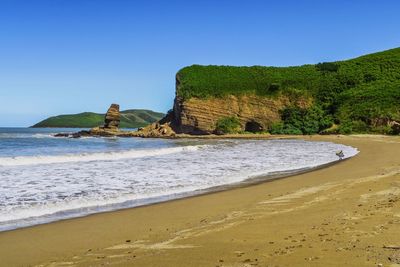 Scenic view of beach against clear blue sky